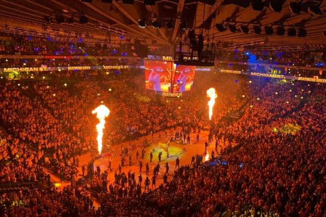 Pyro shoots off before a game inside of a sports arena.