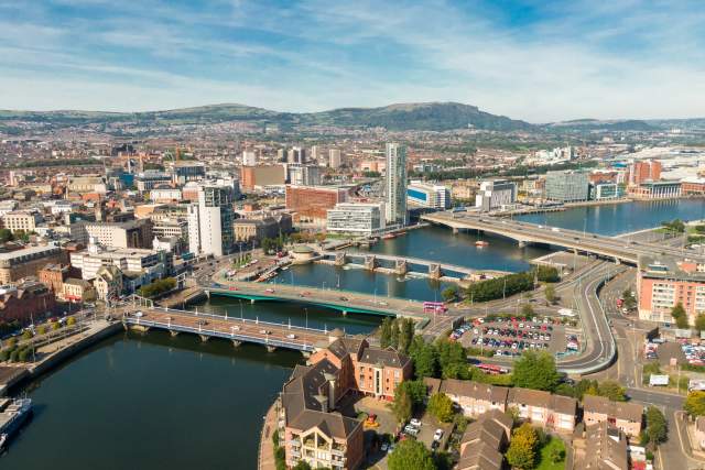 An aerial photo of the river and skyline of Belfast, Ireland on a partly sunny day.