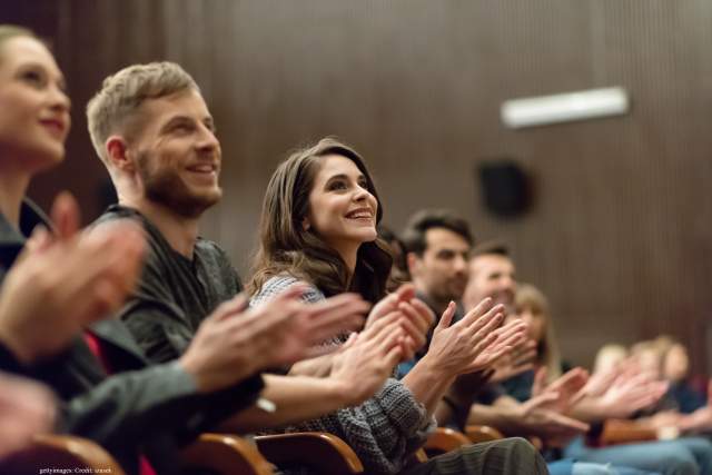 A delighted audience applauding