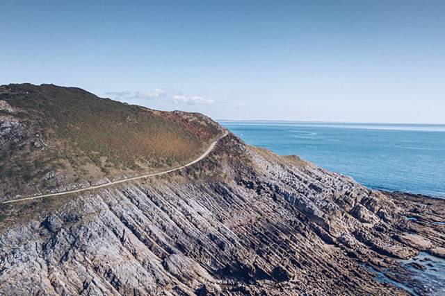 Landscape shot of a path along a ragged coastal edge.