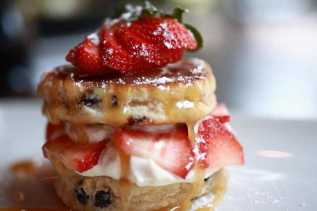 A scone covered in jam and cream.
