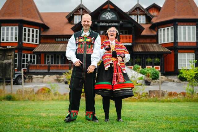 En kvinne og en mann i Setesdalsbunad foran Sølvgarden hotell