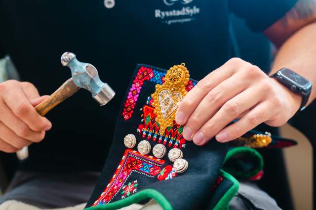 Hender som holder sølv på Setesdalsbunad