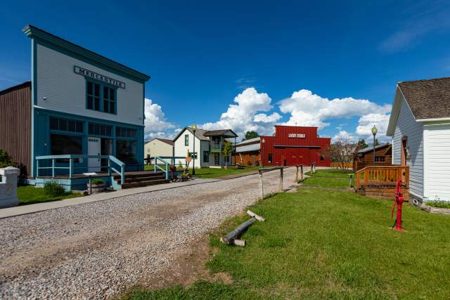 A colorful main street scene with a white mercantile, red livery stable, and historic western buildings in Lander, Wyoming.