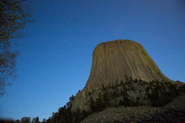 A close-up view of Devils Tower beneath a sky filled with stars.