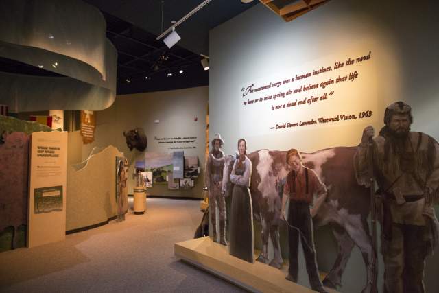 A colorful exhibit with cutout pioneers and quotes about westward expansion at the National Historic Trails Interpretive Center in Casper, Wyoming.