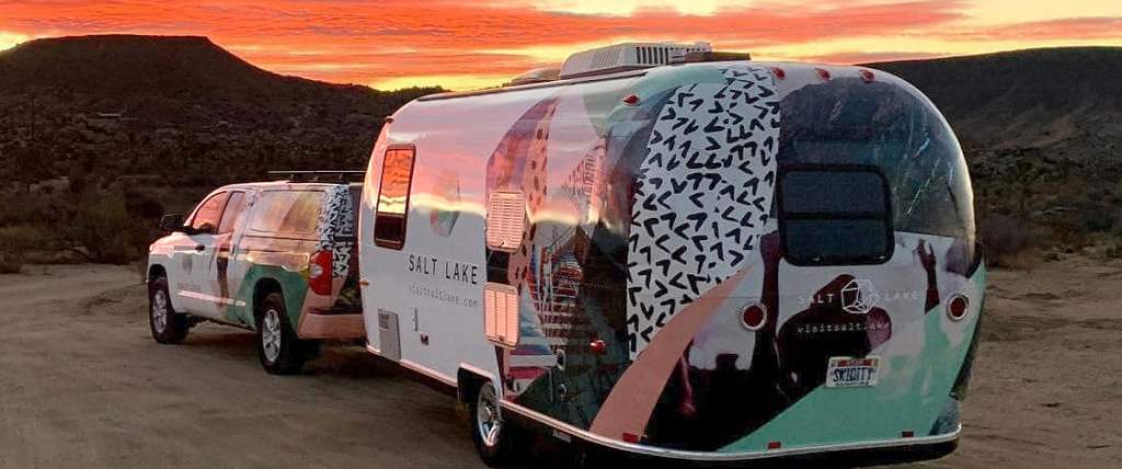 Salt Lake Branded Airstream trailer  pulled by a Salt Lake branded truck at sunset in the mountains