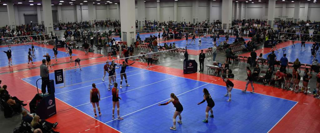 Mountain America Expo Center set up with volleyball courts, players on the court and spectators watching