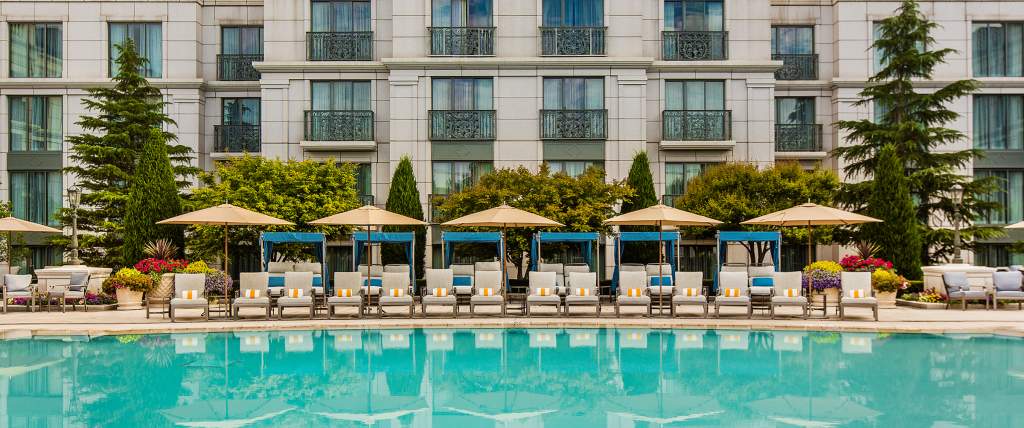 Pool side view of pool, lounge chairs, and hotel at the Grand America Hotel in Salt Lake City