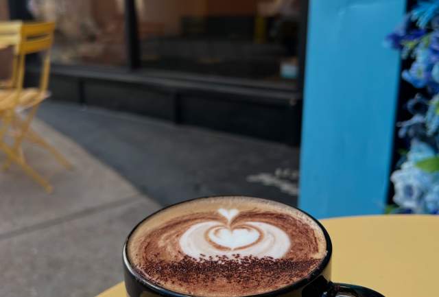 Mug of coffee sitting on a patio table outside