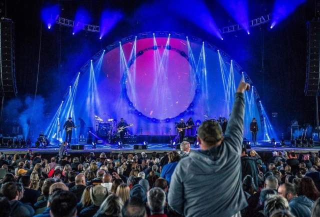 An audience member stands during a concert at Rose Music Center