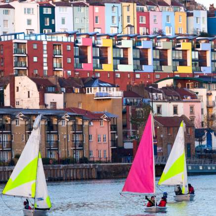 A view of small sailboats on Bristol's Harbourside with the colourful houses of Cliftonwood in the background - credit Paul Box
