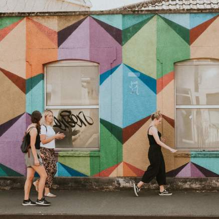 A tour guide leading a group past Paul Monsters mural in Bedminster in South Bristol