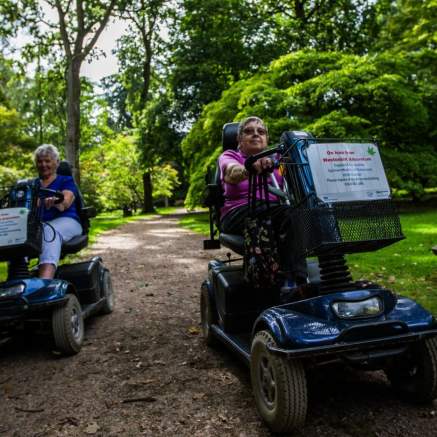 Two mobility scooter users on a path at Westonbirt Arboretum - credit Johnny Hathaway