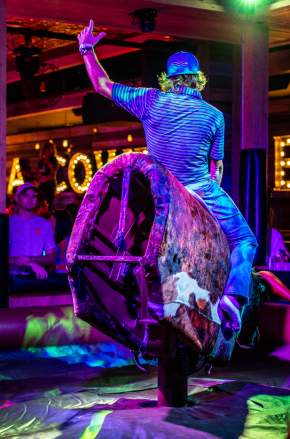 Images for a new venue coming soon to Pointe Orlando. Man riding a mechanical bull