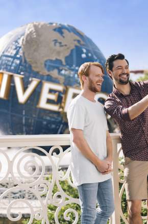 gay couple taking selfie at universal studios globe