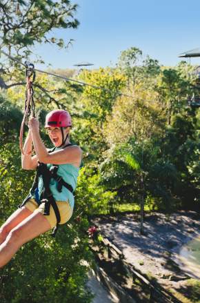 Mature adventurer and teen friends go ziplining at Gatorland