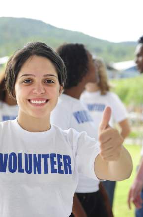 A happy volunteer girl showing a thumbs up sign