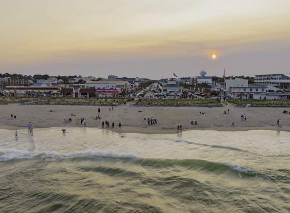 An aerial view of Rehoboth Beach and Rehoboth Beach Boardwalk at sunset.