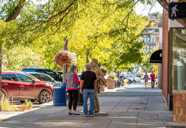 Man and women standing next to Jimmy Carter statue in the spring in the City of Presidents in downtown Rapid City