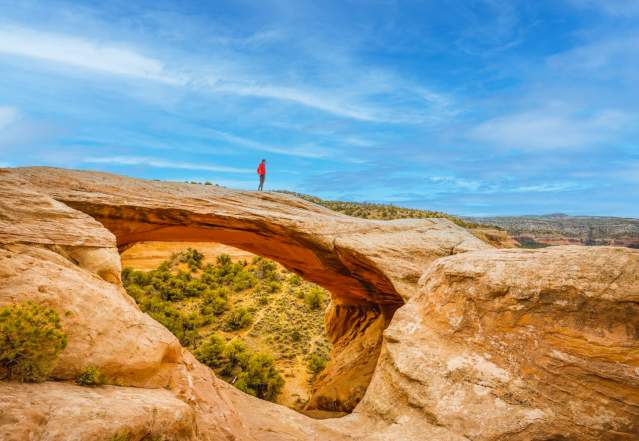 Man walking across Rattlesnake Arches
