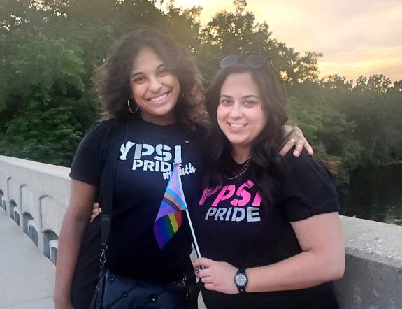 Two women on bridge wearing Ypsi Pride shirts