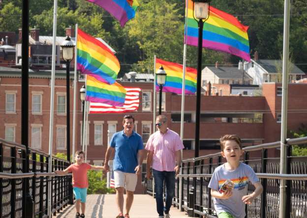 Young family crossing the Pride Bridge in Galena