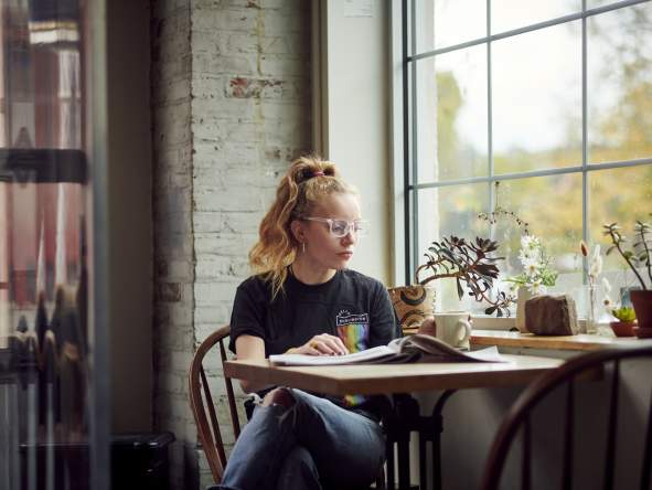 red head girl in cafe reading the news and drinking coffee