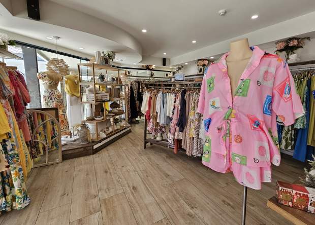 Interior view of a clothing store, with a mannequin on the right showcasing a pink matching set.