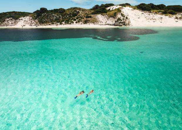 Two friends snorkelling in crystal aqua waters off Rottnest Island
