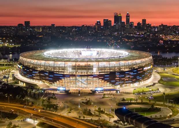 View of Optus Stadium with the Perth Skyline and sunset in the background.