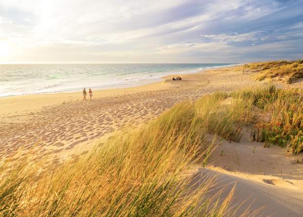 Couple walking along the sand at Preston Beach in Waroona