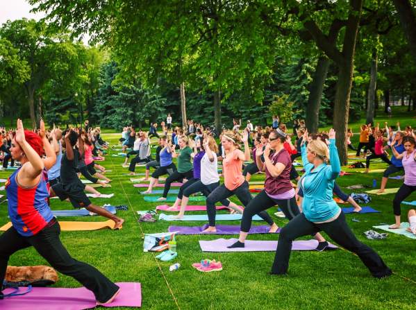 large group doing yoga in a park