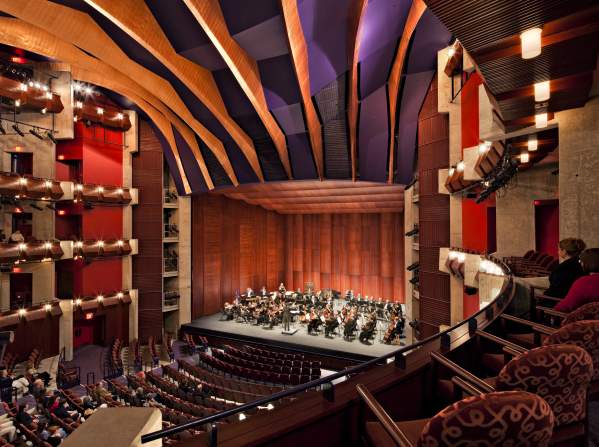 An orchestra performing on stage in a theater