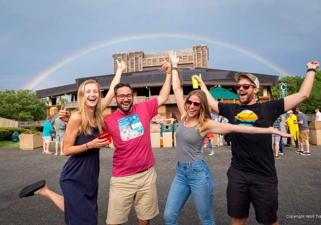 Happy people having fun in front of Wolf Trap with rainbow overhead