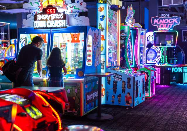 Father and daughter playing an arcade game.