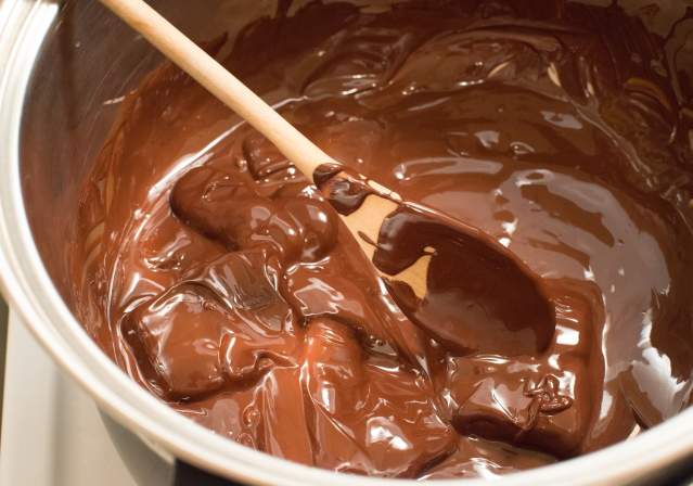 mixing bowl filled with chocolate pudding and a wooden spoon stirring