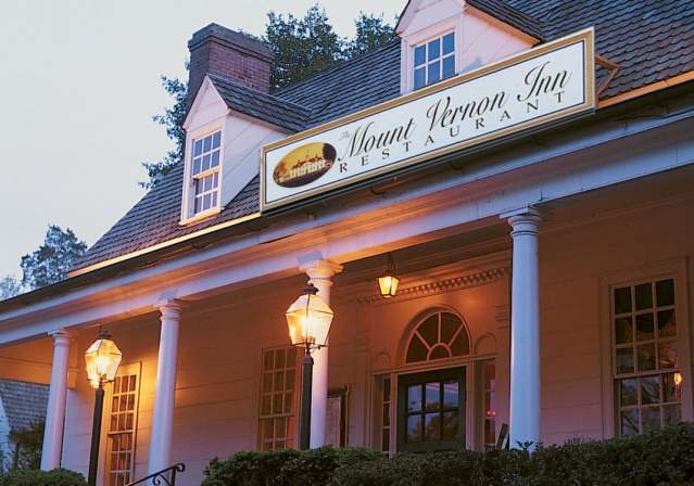 Exterior shot of the Mount Vernon Inn Restaurant in the evening with lanterns lit on the front porch