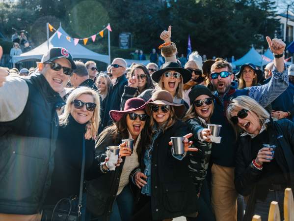 A group of people smiling at Highlands Food & Wine Festival.