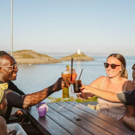Family toasting their glasses with coast in the background