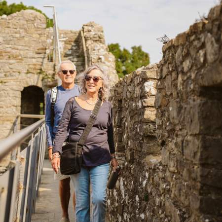 Couple walking along castle ramparts