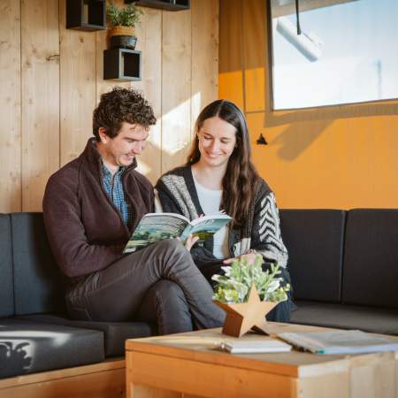 couple sitting on sofa reading book