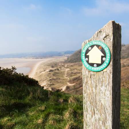 Walking sign post with Crawley beach in the background.