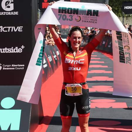 Winner of the Swansea Ironman holding the finishing ribbon