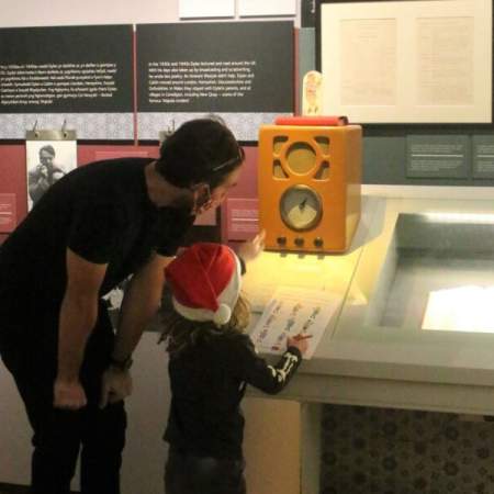 A child and father looking at an exhibit in the Dylan Thomas Centre.