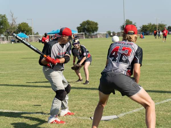 a few men on a baseball field hitting the ball