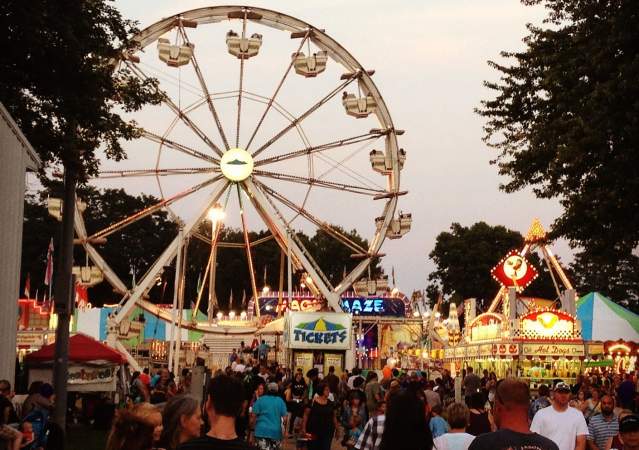 Crowd by food vendors and ferris wheel at the Monroe County Fair