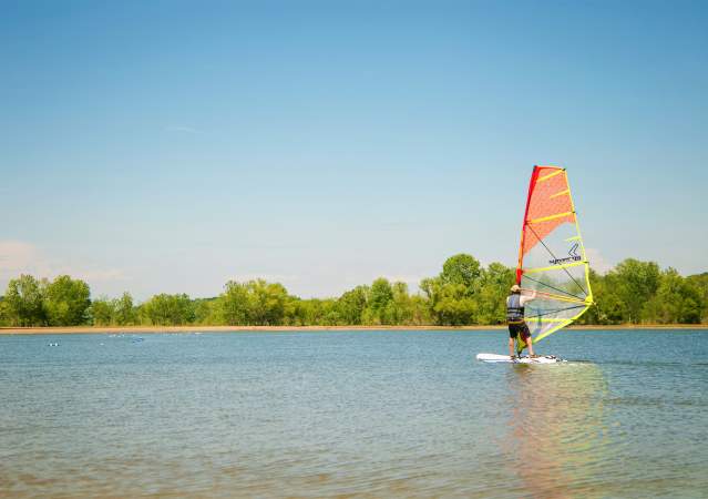 A man windsurfing on Monroe Lake