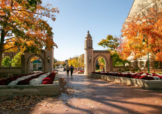 A couple holding hands while walking through Sample Gates