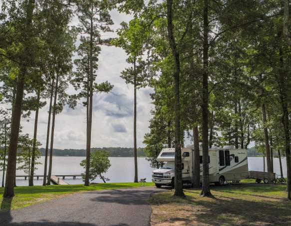 RV in Wooded Area by Water